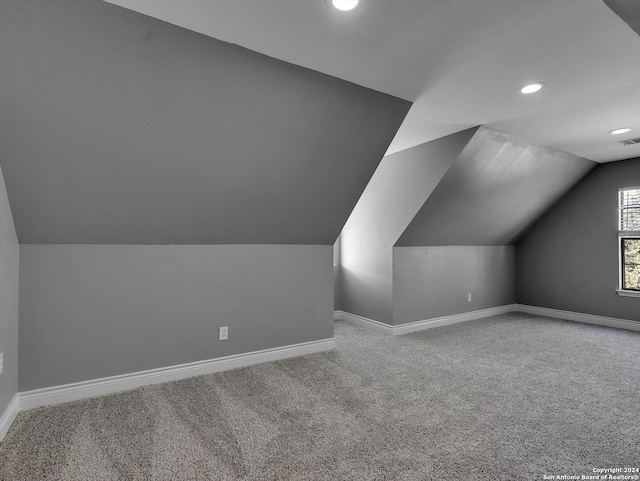 bonus room with lofted ceiling and carpet floors