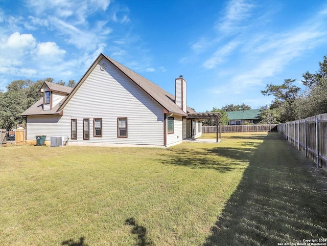 rear view of property featuring cooling unit, a pergola, and a lawn