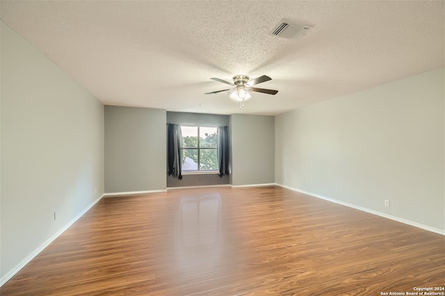 unfurnished room with hardwood / wood-style flooring, ceiling fan, and a textured ceiling