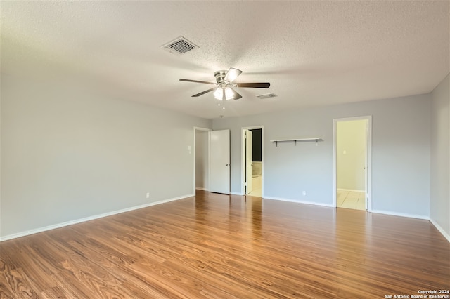 unfurnished room with a textured ceiling, hardwood / wood-style flooring, and ceiling fan