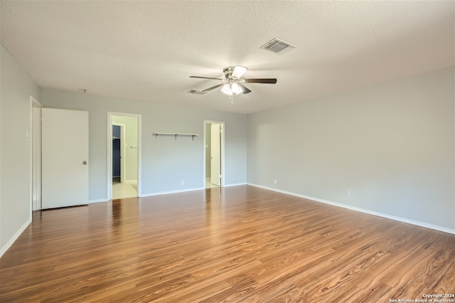 spare room featuring light hardwood / wood-style floors, ceiling fan, and a textured ceiling