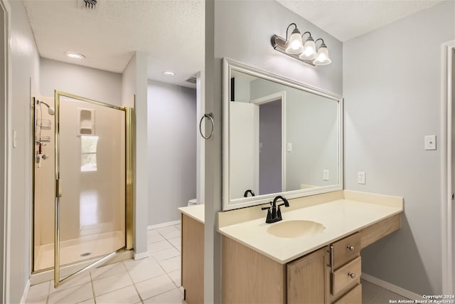 bathroom with an enclosed shower, vanity, a textured ceiling, and tile patterned floors