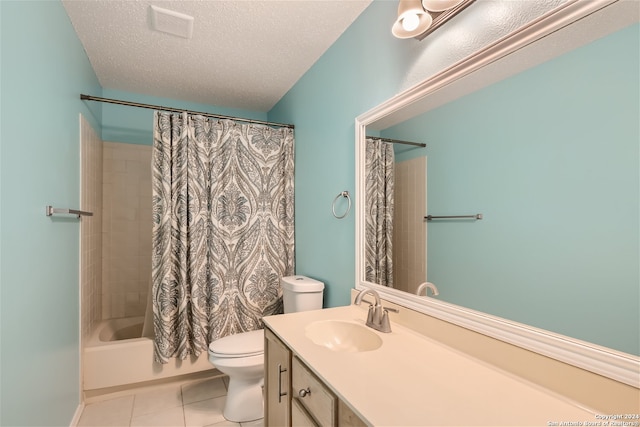 full bathroom with a textured ceiling, shower / tub combo with curtain, vanity, tile patterned floors, and toilet