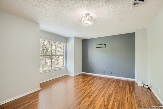 spare room with hardwood / wood-style floors and a textured ceiling