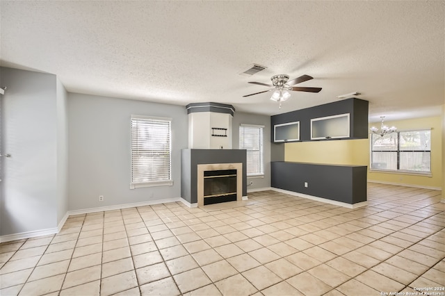 unfurnished living room featuring a wealth of natural light, a textured ceiling, and light tile patterned floors