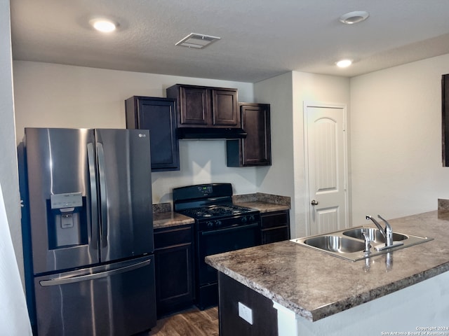 kitchen with sink, stainless steel fridge, a textured ceiling, dark wood-type flooring, and black range with gas cooktop