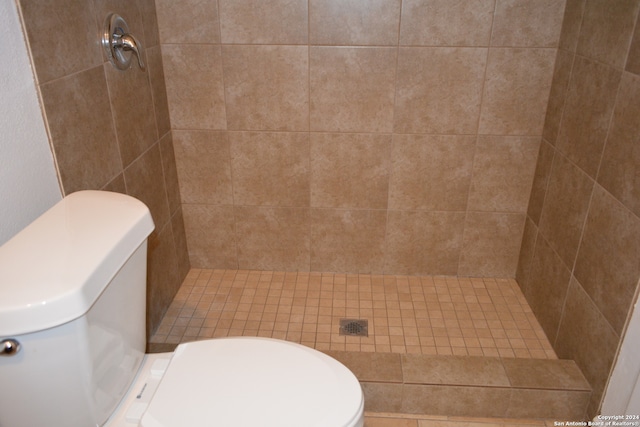 bathroom featuring toilet and tiled shower