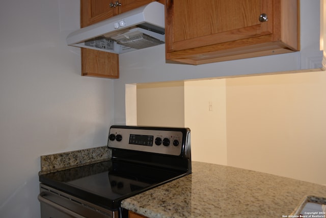 kitchen with light stone counters and stainless steel range with electric cooktop