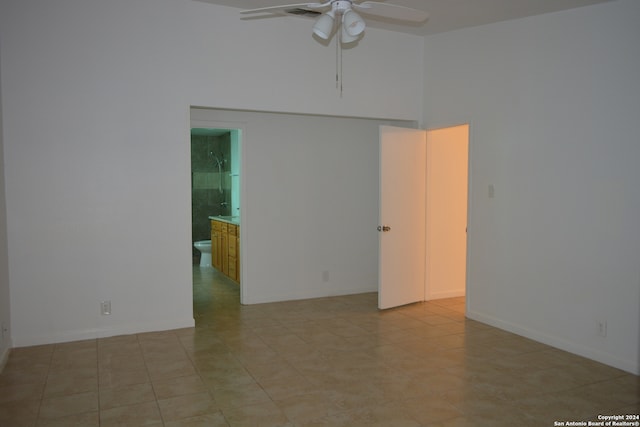 tiled spare room with a towering ceiling and ceiling fan