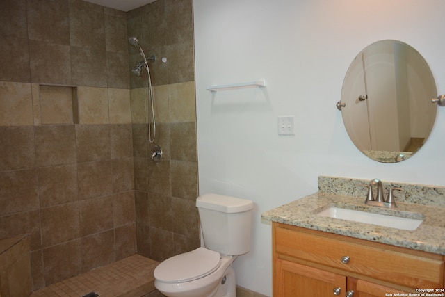 bathroom featuring vanity, toilet, and tiled shower