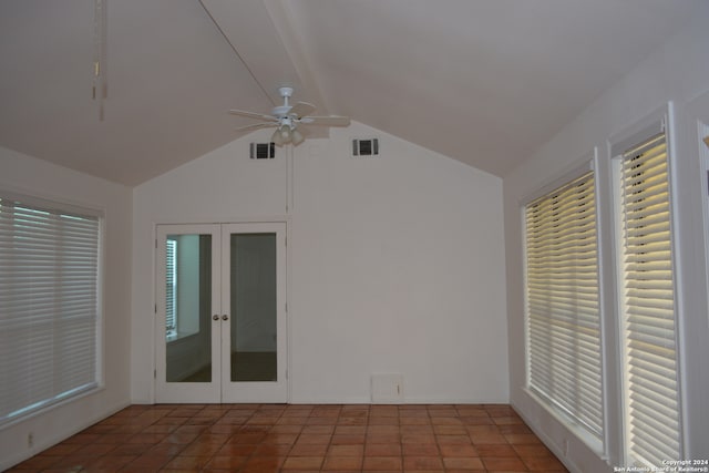 tiled empty room with lofted ceiling, french doors, ceiling fan, and plenty of natural light