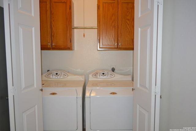 laundry area with washer and clothes dryer and cabinets