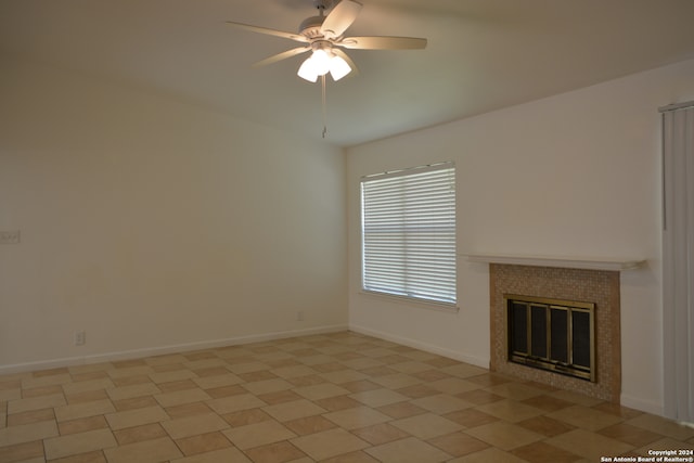 unfurnished living room featuring a tiled fireplace and ceiling fan