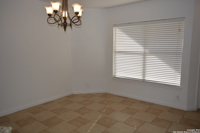 spare room with a chandelier