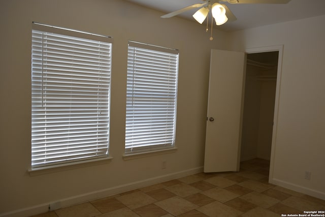 unfurnished bedroom featuring ceiling fan and a closet