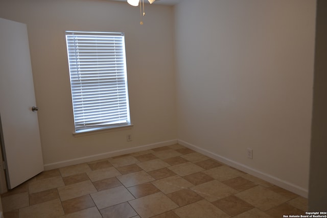 spare room with ceiling fan and plenty of natural light