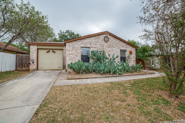 ranch-style house featuring a garage and a front lawn