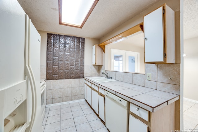 kitchen with sink, white appliances, a textured ceiling, and white cabinets