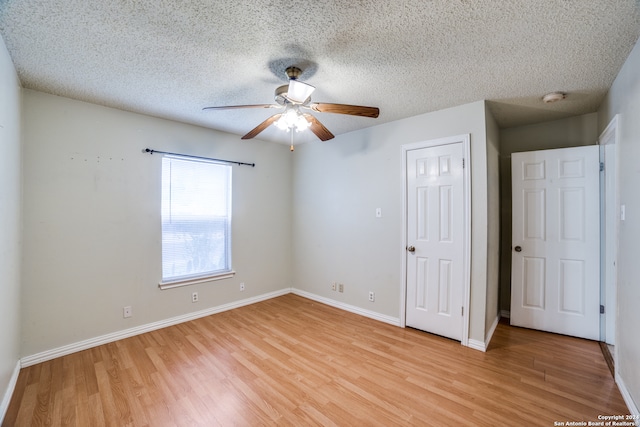 unfurnished bedroom with a textured ceiling, ceiling fan, and light hardwood / wood-style flooring