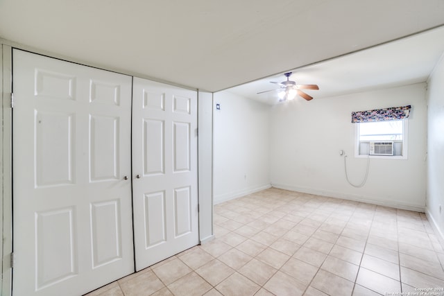 unfurnished bedroom featuring a closet, cooling unit, ceiling fan, and light tile patterned flooring