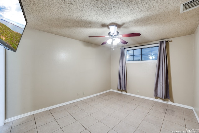 unfurnished room featuring a textured ceiling, light tile patterned floors, and ceiling fan