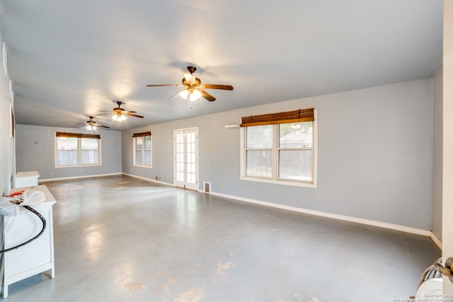 unfurnished living room with concrete floors and ceiling fan