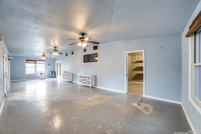 unfurnished living room with concrete flooring and a textured ceiling