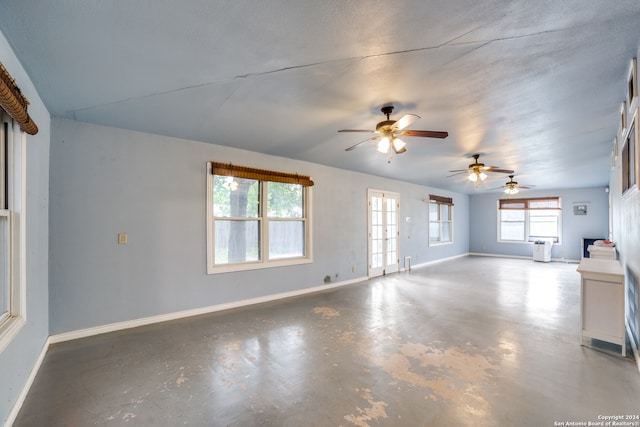 unfurnished living room with ceiling fan, concrete floors, and a textured ceiling