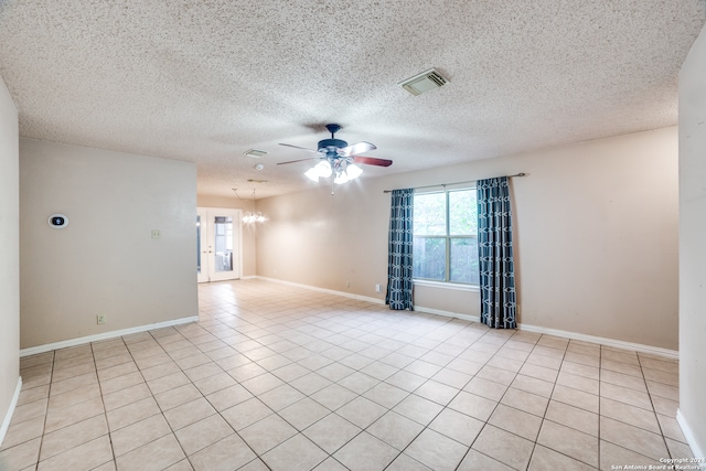 spare room featuring ceiling fan with notable chandelier, a textured ceiling, and light tile patterned floors