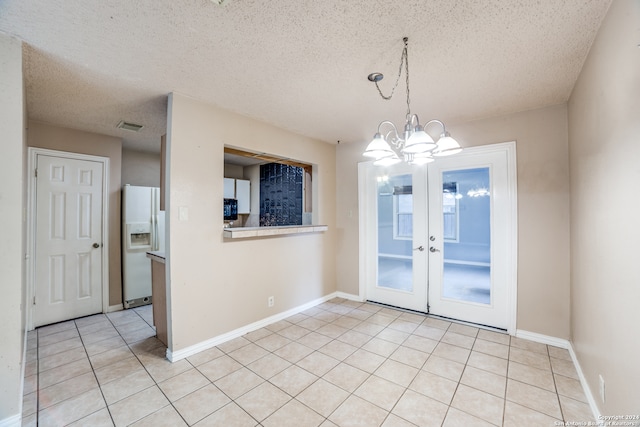 unfurnished dining area featuring french doors, a textured ceiling, a chandelier, and light tile patterned flooring