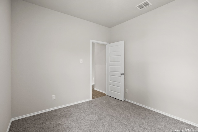 spare room with dark colored carpet