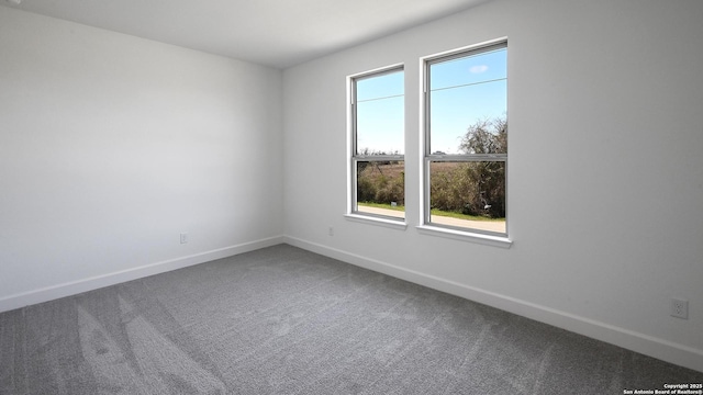 carpeted spare room with baseboards