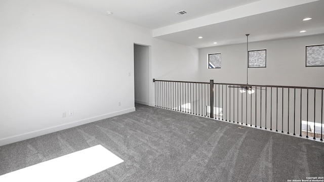 carpeted empty room with baseboards, visible vents, and recessed lighting