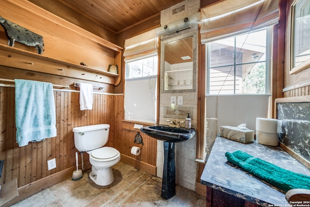 bathroom featuring wooden ceiling, wooden walls, and toilet