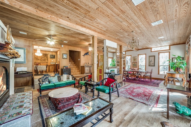 living room featuring wooden ceiling, wood-type flooring, wood walls, and ceiling fan with notable chandelier