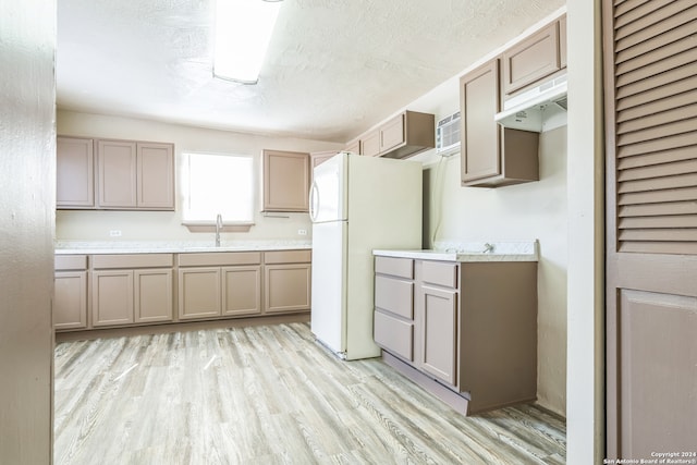 kitchen featuring light wood-type flooring, a textured ceiling, and white fridge