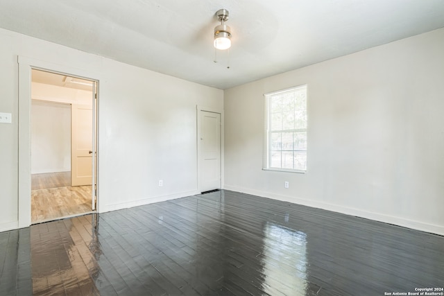 unfurnished room featuring dark wood-type flooring and ceiling fan