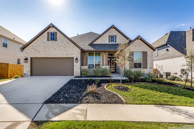 view of front of house featuring a garage, cooling unit, and a front yard