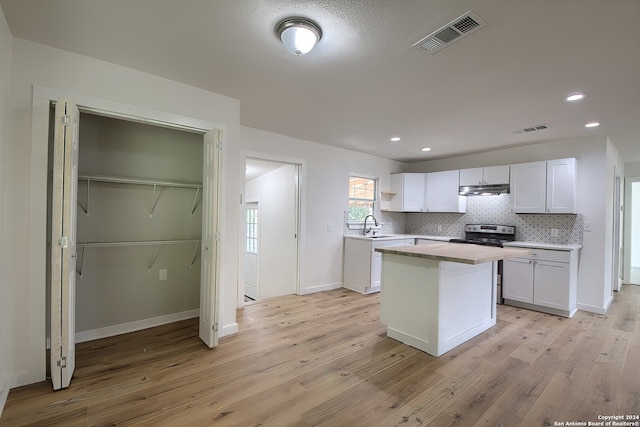 kitchen featuring white cabinetry, light wood-type flooring, and electric stove