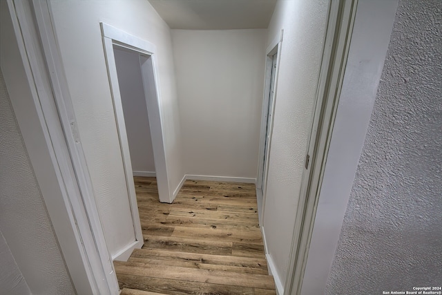 corridor with light hardwood / wood-style floors