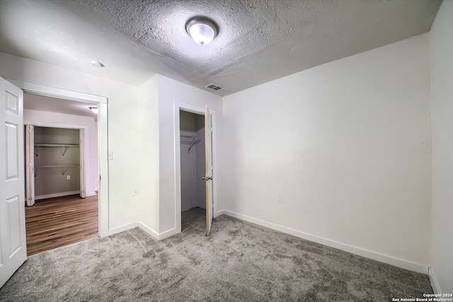 unfurnished bedroom with a closet, a textured ceiling, and carpet flooring