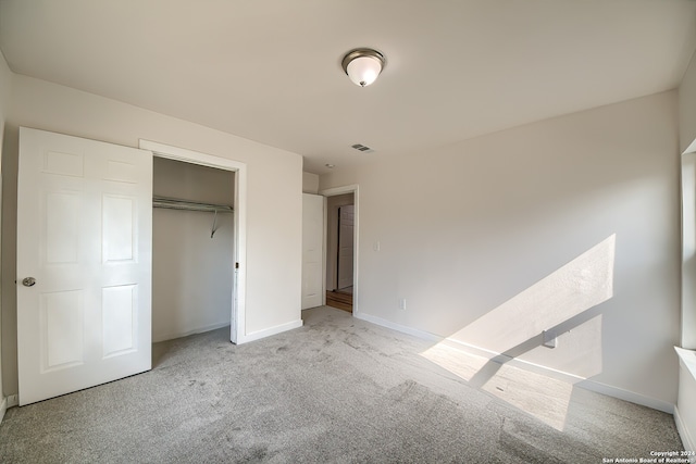 unfurnished bedroom with light carpet and a closet