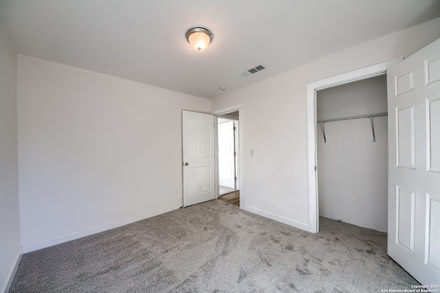 unfurnished bedroom featuring light colored carpet and a closet