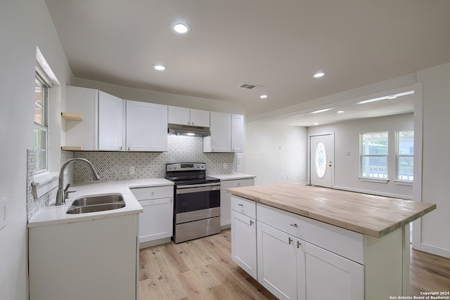 kitchen with white cabinets, sink, stainless steel range with electric cooktop, and a center island