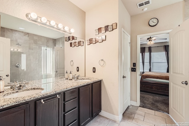 bathroom featuring tile patterned flooring, vanity, ceiling fan, and a tile shower