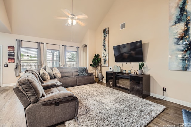 living room with hardwood / wood-style flooring, ceiling fan, and high vaulted ceiling