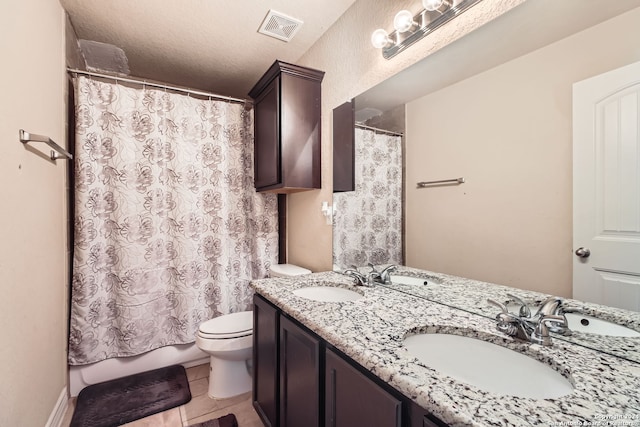 bathroom with tile patterned floors, toilet, curtained shower, a textured ceiling, and vanity