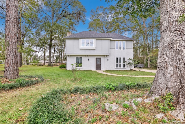 rear view of property featuring a lawn