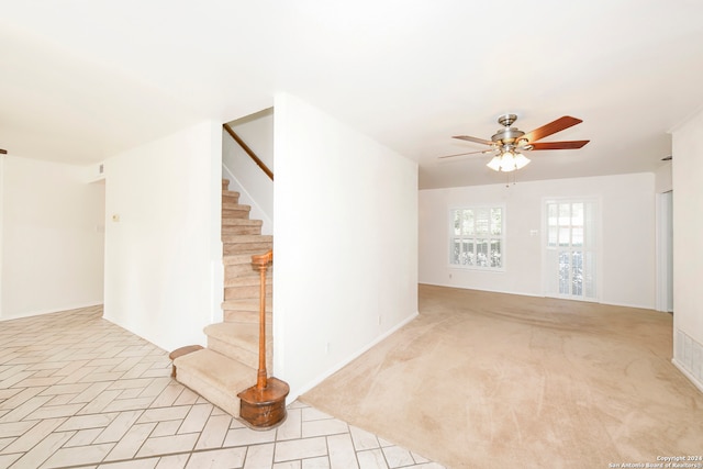 carpeted spare room featuring ceiling fan