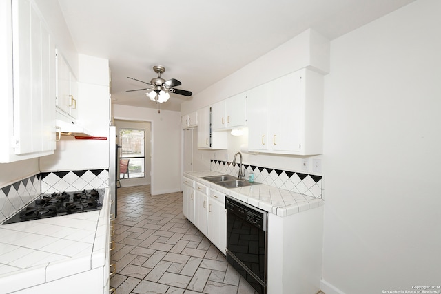 kitchen featuring tile countertops, white cabinets, decorative backsplash, black appliances, and sink